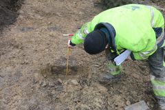 Arkæolog måler på stolpehul i udgravning