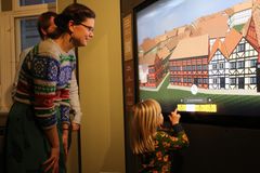 Mor og barn ved touch screen til 3D model af Rådhuspladsen