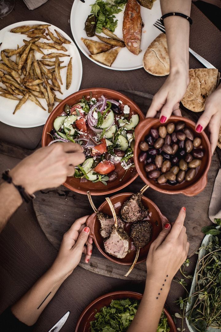 Omgivelserne betyder meget for vores lyst til at spise anderledes på ferien. En græsk salat med lammekoteletter og oliven gør sig godt på en græsk taverna.