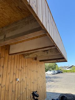 Foto af et tag, hvor det er tydeligt at nogle af de bærende bjælker er gamle, mens det øvrige træ er nyt.