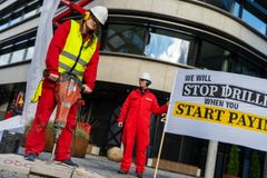En Greenpeace-aktivist borer her for at komme ned til nogle af olieselskabet TotalEnergies mange oliepenge, så de kan begynde at betale for deres klimaskader.