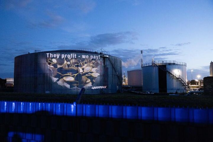 “De tjener, vi betaler” bliver projiceret op på et brændstoflager på Hamborg Havn i protest mod de svimlende overprofitter på det tyske benzinmarked.
