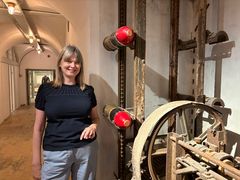 Bente Vinge Pedersen står ved siden af en original granatelevator i kasematterne på Mosede Fort