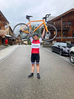 Mathias Henne Grau på toppen af Alpe d'Huez på sin Arkil farvede racercykel.