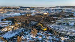 Når et skib har læsset 5.000 ton jord af på kajen et par kilometer fra byggepladsen, bliver der travlt med at fordele jorden over det store areal.