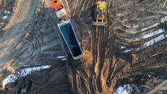 Over walkie’en får chaufføren at vide, hvilken bås jorden skal tippes af i. Her holder en bulldozer klar til at jævne de 38 ton jord ud med det samme.