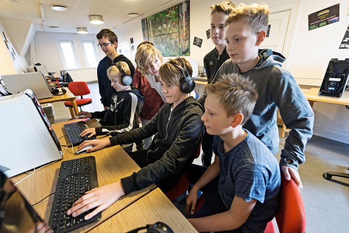 En række børn er samlet for at spille computerspil.