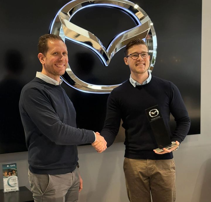 Mazda-repræsentant overrækker prisen “Mazda Kundetilfredshed 2025” til Mazda-ansvarlige Simon Boelt Hansen fra N.O. Jensen.