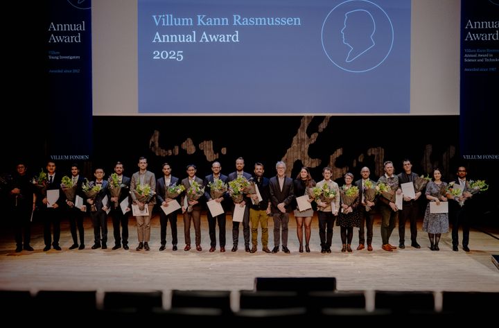 Gruppe mennesker står på en scene med diplomer og blomster. Bag dem ses et skilt med "Villum Kann Rasmussen Annual Award 2025".