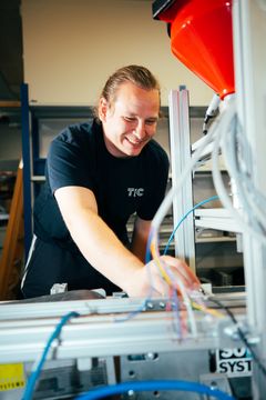 En person arbejder med automationsudstyr på et TEC-træningscenter.