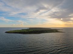 Billede af Asnæs halvø set fra havet i solnedgang med skyer og blåt hav.