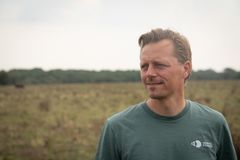 Billede af en person, der står udenfor på en mark og bærer en T-shirt med Hempel Fonden logo.