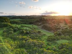 Luftfoto af Molslaboratoriet ved solnedgang, med frodige grønne landskaber og bakker.