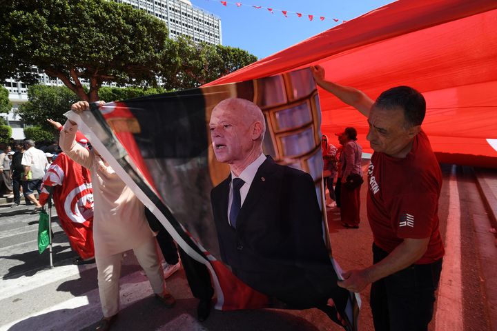 Backing for the President: Supporters of Tunisian President Kais Saied hold his image during a rally in Tunis, on July 25, 2024, as the nation celebrates the 67th anniversary of foundation of the republic. Photo by Fethi Belaid / AFP