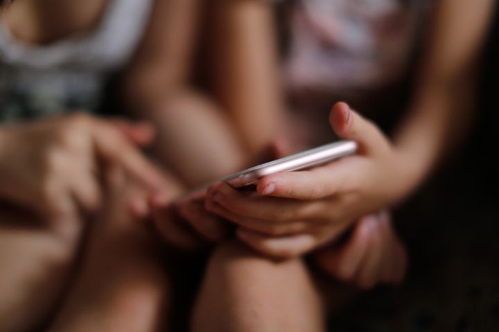 To børn kigger sammen på en smartphone.