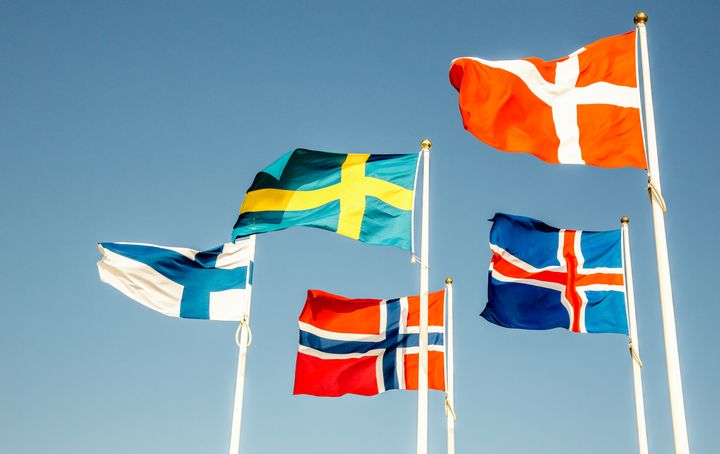 Fem nordiske flag blafrer i vinden fra hver deres flagstang