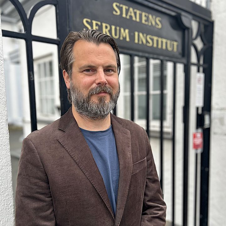 Mand ståf foran jernlåge, hvorpå der med guldbogstaver står Statens Serum Institut