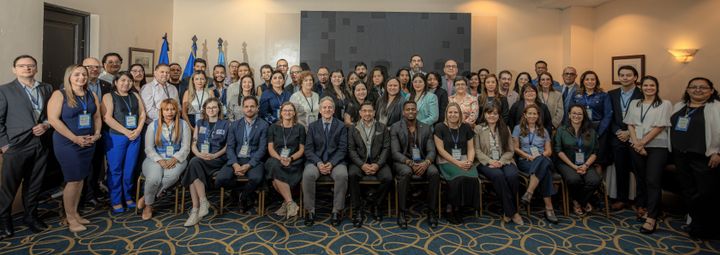 Gruppefoto af mange mennesker opstillet i et rum