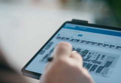 Person bruger OneSync på tablet til at overvåge ventilationsanlæg og energiforbrug.