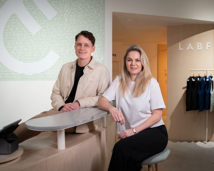 To personer sidder ved en skranke i en moderne butik.