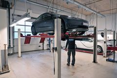 Testassistent står under grå Tesla på lift