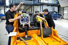 Teknikere spænder testdukker fast i autostole inden crashtest