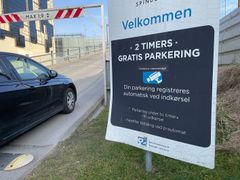 Bil kører forbi p-skilt med automatisk nummerpladeaflæsning.