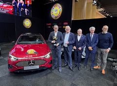 Mercedes-Benz repræsentant får overrakt The Car of the Year-trofæ foran rød bil