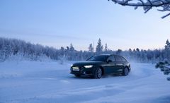 Sort bil kører i øde vinterlandskab
