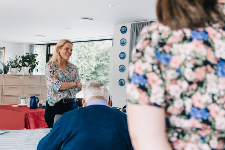 Mette Kierkgaard står foran en forsamling og taler.