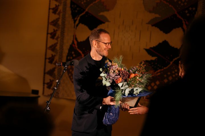 Joachim Trier får her overrakt Hammerich-Prisen 2024 af Hanne Bjurstrøm, styreleder i Fællesstyret og i det norske styre i Fondet for Dansk-Norsk Samarbejde. Prisoverrækkelsen foregår på Lysebu i Oslo.