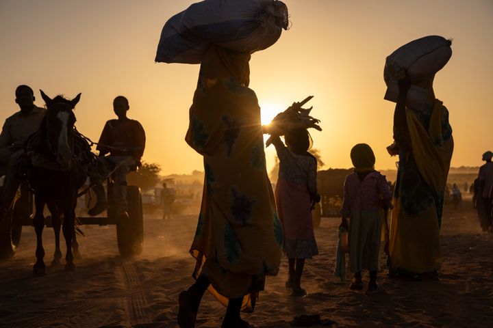 En gruppe sudanesiske flygtninge ved grænsen mellem Sudan og Tchad ved solnedgang.