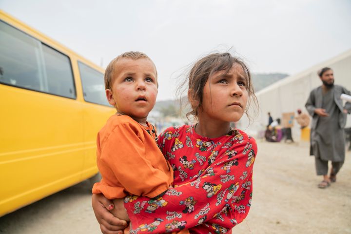 Sheerin Jan, 11 år, holder sin lillesøster Hafsa, 2 år, tæt ind til sig, mens de sammen er på vej over grænsen tilbage til Afghanistan.