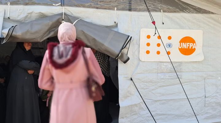 Kvinder og piger opsøger et UNFPA-støttet “Safe Space” for kvinder og piger, som tilbyder sine ydelser fra et telt opstillet uden for en skolebygning, som i øjeblikket huser fordrevne i Gaza by.