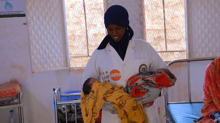 En jordemoder holder to tvillinger på en UNFPA-støttet neonatal sundhedsfacilitet i Baidoa, Somalia.