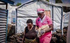 Midwife Loti Kubuya Mielor assists a newly arrived displaced woman who gave birth in a shelter in Goma, the Democratic Republic of the Congo, later guiding her to a nearby UNFPA-supported mobile health clinic for essential postnatal care and follow-up.
