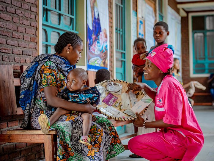 En mor holder sit barn, mens hun modtager information om prævention fra jordemoder Julie Masika på Turunga Health Centre i Goma, Nord-Kivu-provinsen.