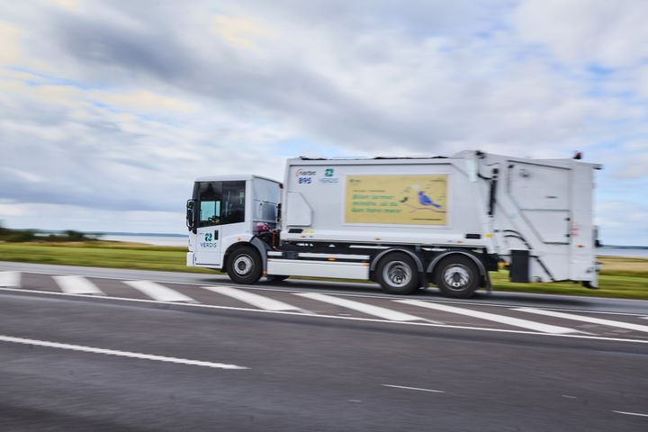 Eldreven renovationsbil fra Verdis kører på vej i åbent landskab