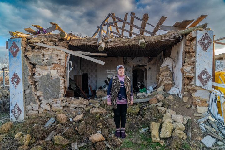 Valentyna Zavadska, 64, outside the remains of her house near Mykolaiv, which was destroyed by artillery in March 2022. She received support from UNHCR's local NGO partner to refurbish an adjoining building in which to live. © Sverige för UNHCR/Felicia Monteverde Holmgren