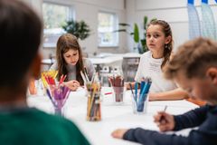 Børn sidder om et bord med farveblyanter som illustration på en nyhed om et nyt skriveværksted der åbner for Børn i Billund Kommune