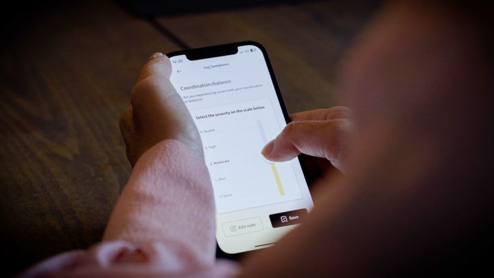 A person using a smartphone app with graphs and data.
