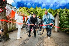 Udendørs ceremoniel båndklipning til lancering af Danmarks Rekreative Cykelnet omgivet af blå balloner og flag.