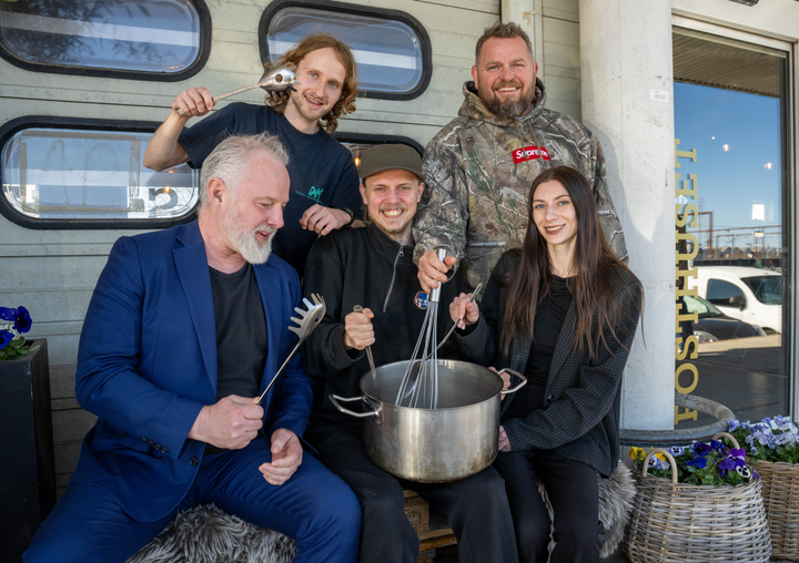 Samarbejdspartnerne bag fællesspisningen omkring en stor gryde foran Posthuset.