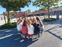 En gruppe piger sidder omkring et bord i skolegården