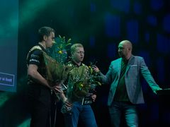 To personer står med blomster i hænderne og bliver interviewt af en vært.