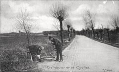 To mænd ved en landevej reparerer en cykel.