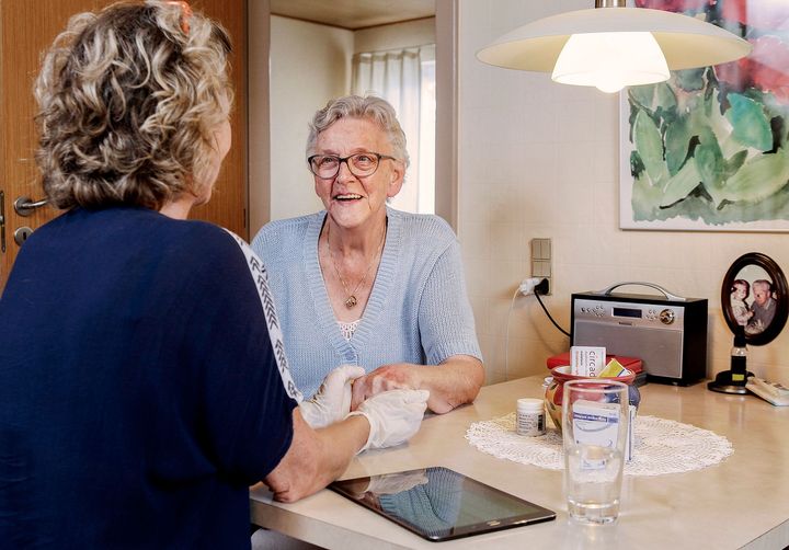 Kommunal medarbejder på besøg hos ældre kvinde
