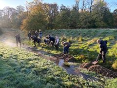 Skolebørn fra Oust Mølle Skole i fuld gang med lægge gydegrus ud i Svejstrup Bæk.