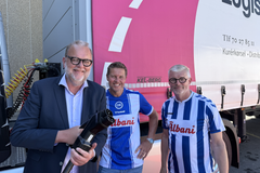 Tidligere Energi- og klimaminister Lars Christian Lilleholt (tv.) sætte strøm til første ellastbil sammen med Logistik Centralens ejere, Morten Christensen og Dennis Just (th.).