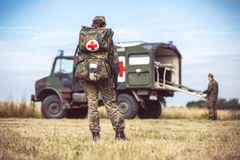 Paramedic in front of military ambulance
